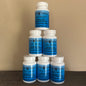 Five white plastic supplement bottles with blue labels stacked in a pyramid arrangement on a dark wooden surface against a beige wall. The labels read 'TOP SHELF ELK VELVET'.